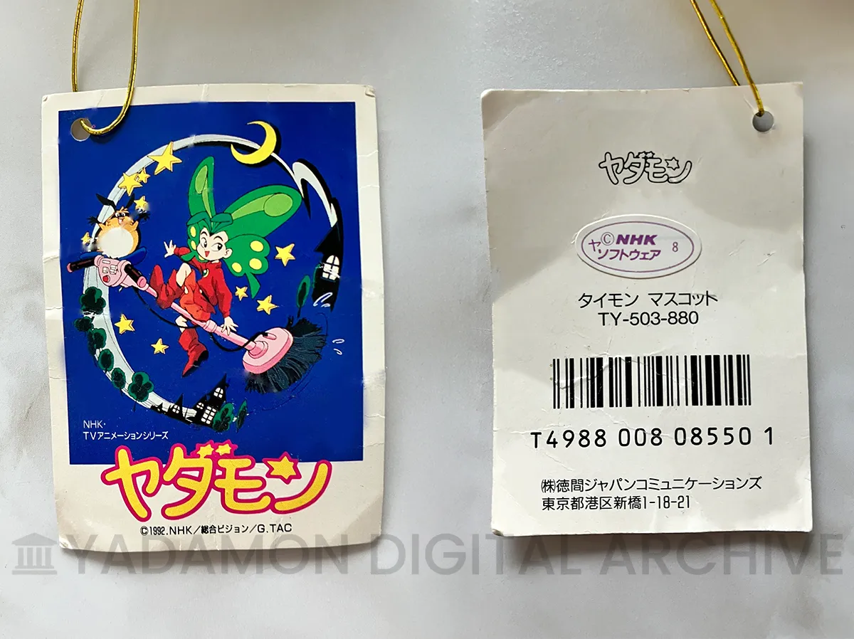 タイモン マスコットサイズ ぬいぐるみ タグ。販売元:徳間ジャパンコミュニケーションズ。Taimon mascot-size plush tag. A product of Tokuma Japan Communications Co., Ltd.